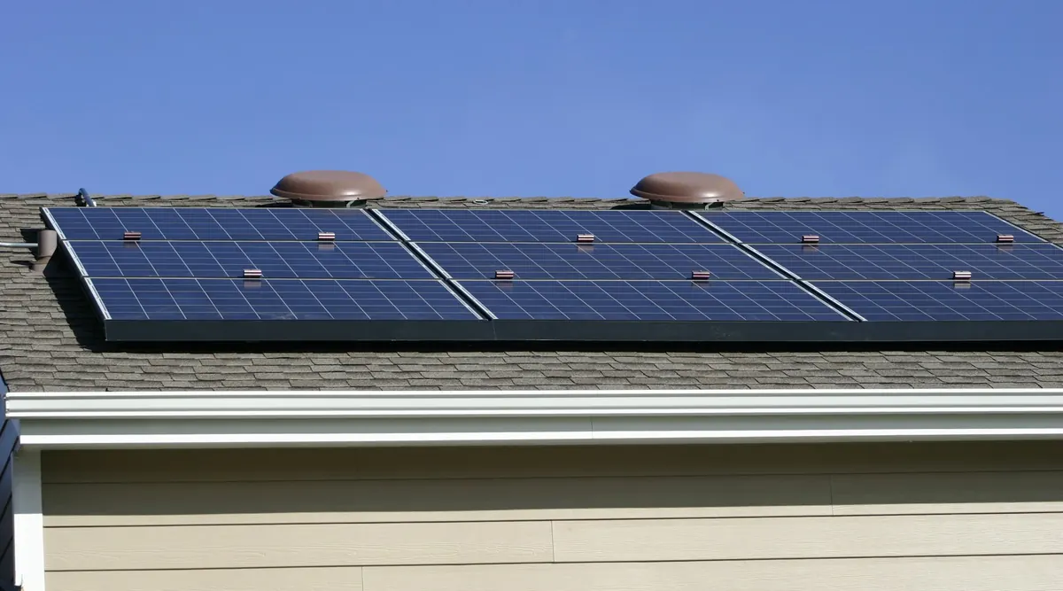 Paneles solares instalados sobre el techo de una vivienda bajo un cielo despejado